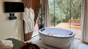 Une salle de bain moderne avec une grande baignoire, un espace douche et un plafond en bois.