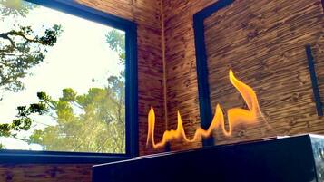 A modern interior with a fireplace, large windows, and wooden walls.