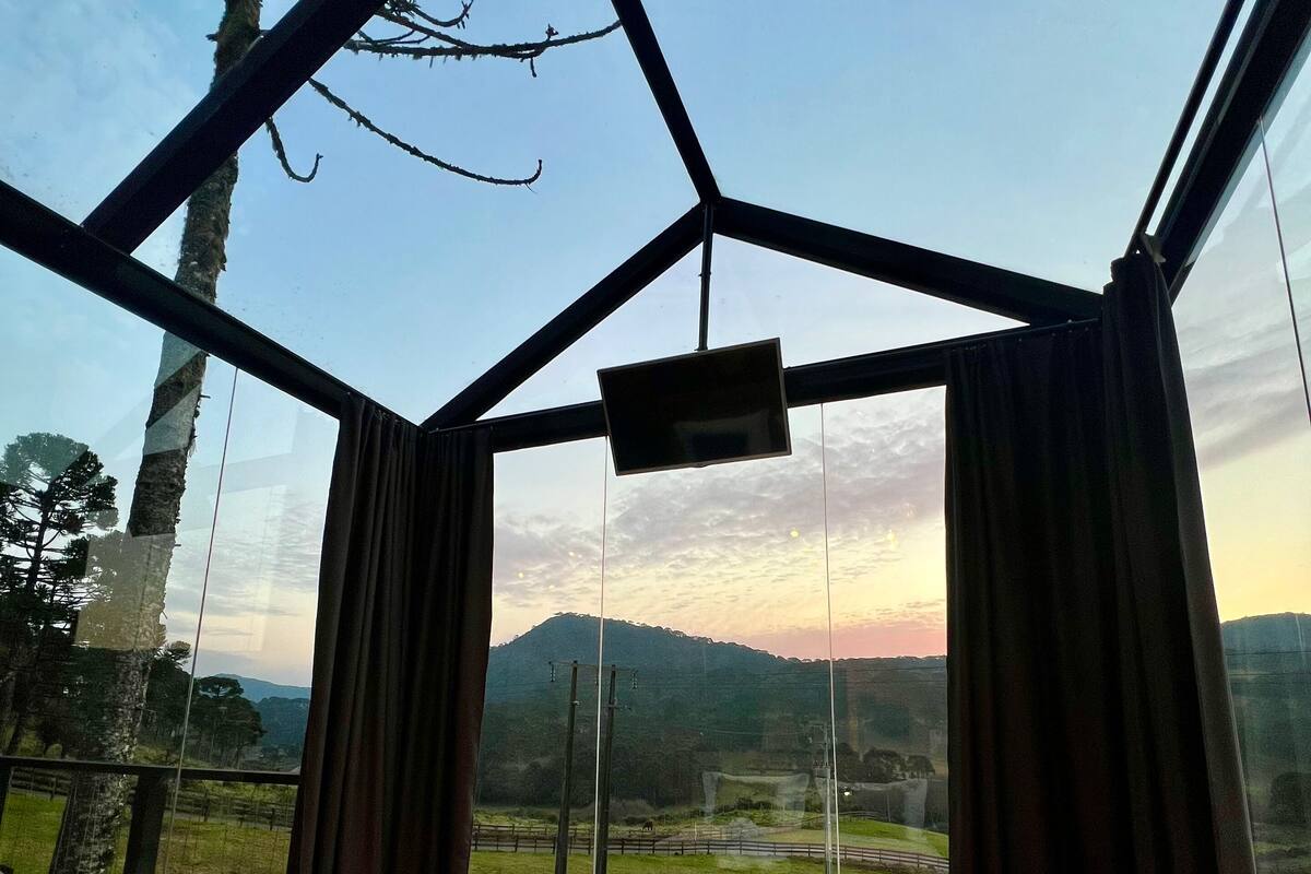 Une chambre avec un grand lit, une télévision et une vue sur un paysage montagneux.