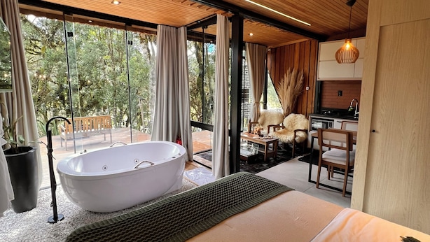 Une chambre moderne dotée d’un grand lit, d’une baignoire sur pieds, d’un coin repas et d’une cuisine.