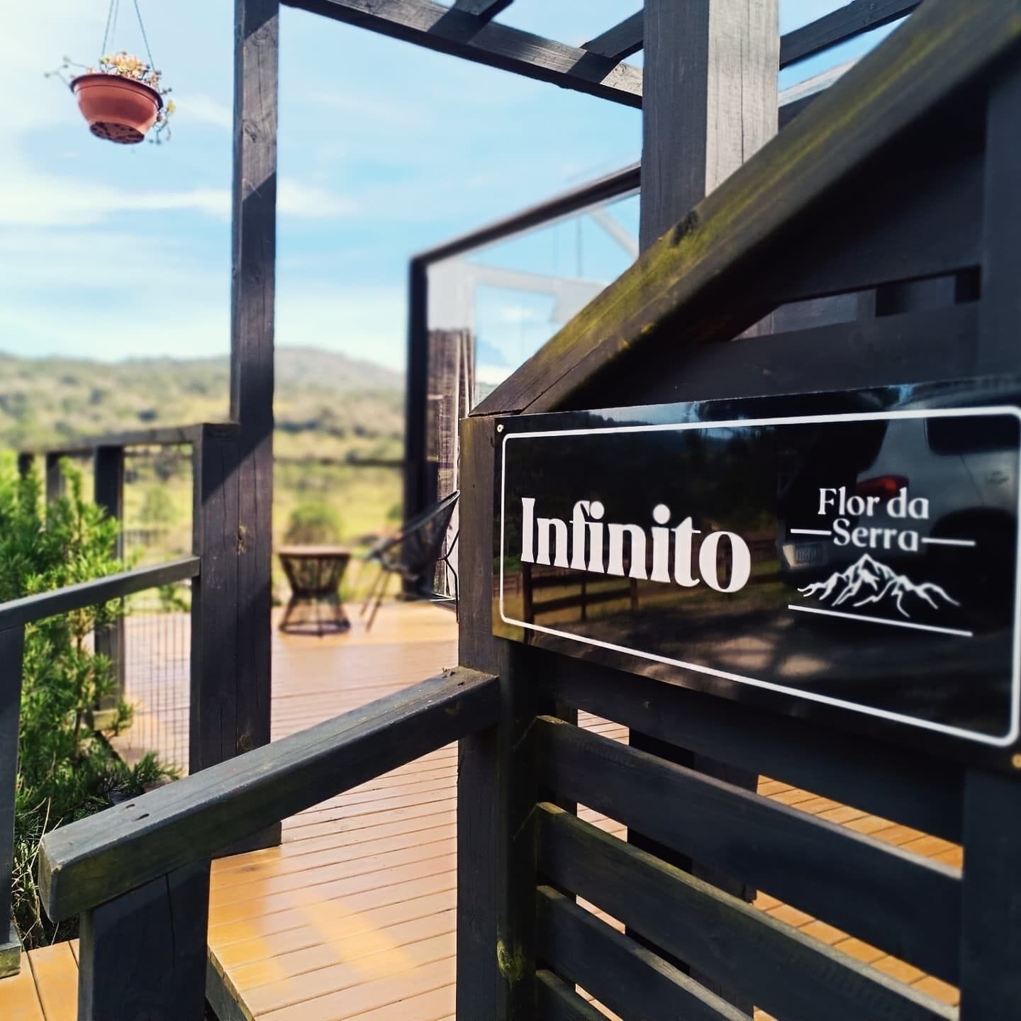A wooden deck with a sign reading "Infinito Flor da Serra".