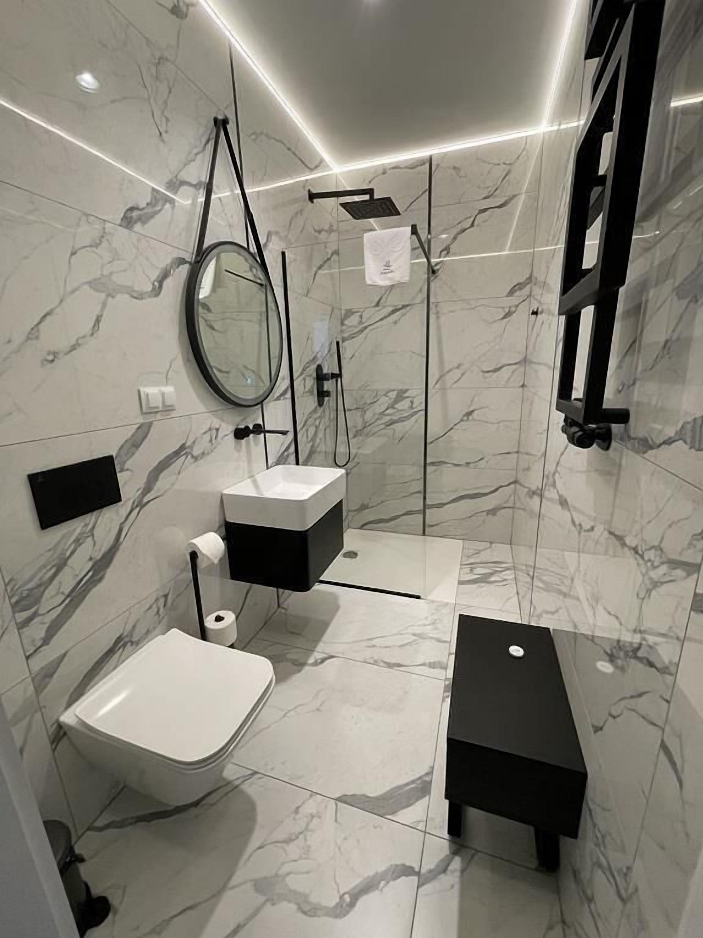 A modern bathroom with a toilet, bidet, and a shower area.