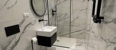 A modern bathroom with a toilet, bidet, and a shower area.