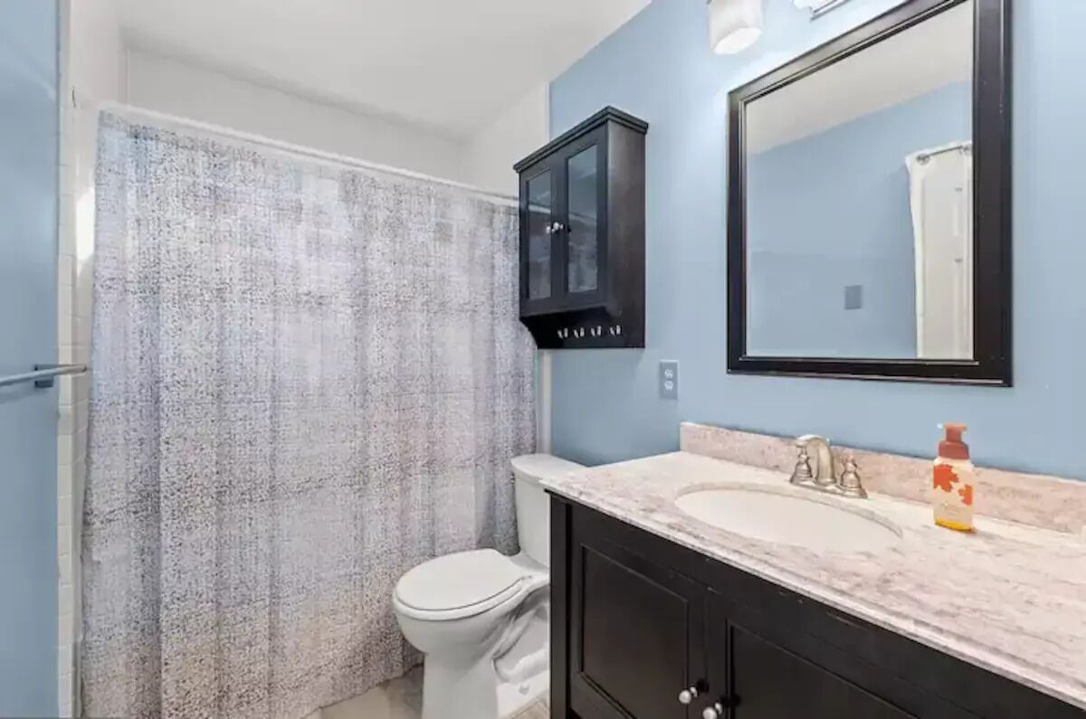 Une salle de bain équipée d’une douche, de toilettes, d’un lavabo et d’un meuble de rangement.
