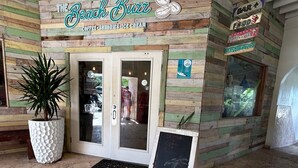 Un bar à thème balnéaire, avec une façade en bois, une enseigne et un menu écrit à la craie.