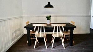 Un coin repas avec une table en bois foncé et deux chaises en bois clair.