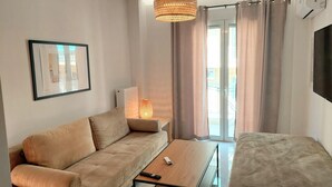 A modern living room with a sofa, a coffee table, and a TV. - Wonderful apartment in Acropolis (Athina)