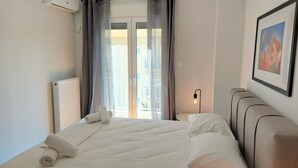 Una habitación de hotel con una cama, un radiador, una mesita de noche con una lámpara y un cuadro en la pared.