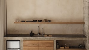Una cocina compacta con lavavajillas integrado, armarios de madera y un lavamanos de acero inoxidable.