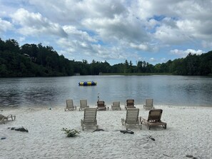 A lakeside setting with beach chairs and a floating device.