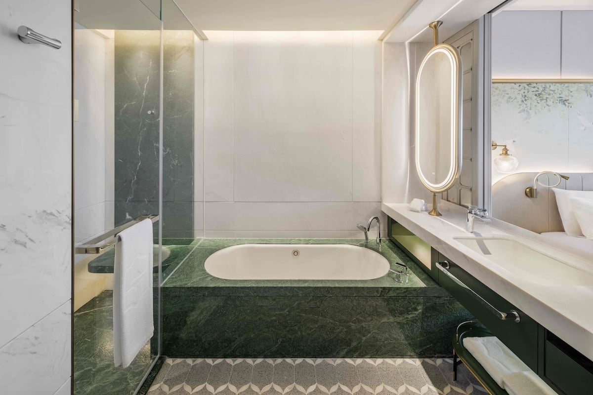 A modern bathroom with a freestanding bathtub, a glass shower enclosure, and a vanity with a mirror.