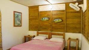A bedroom with a wooden headboard, a pink bedspread, and a nightstand.