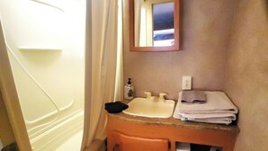 Een badkamer met een bad, een wastafel, een spiegel en een toilet.