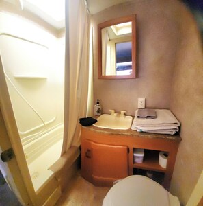 Une salle de bain avec une baignoire, un lavabo, un miroir et des toilettes.