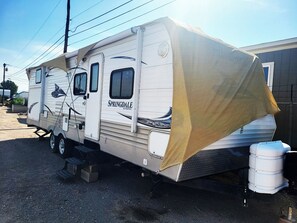 Un grand camping-car doté d’un espace de couchage abrité, d’une cuisine et d’une salle de bain.