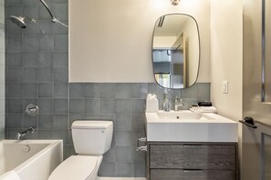 A modern bathroom with a bathtub, toilet, and sink.