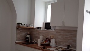 A modern kitchen with white cabinets, a microwave, a sink, and a window. - Vacation home (Historical Center) CATANIA (Catania)