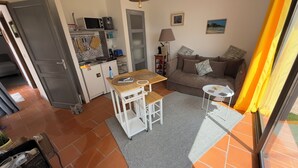 Ein kompakter Wohnbereich mit Küchenzeile, Essplatz und Sofa.