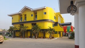 Un edificio giallo con numerosi balconi e un cortile lastricato.