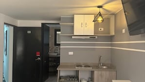 A compact kitchen with modern appliances, a built-in oven, and a microwave. There is a small sink and a white countertop. - Hotel Gran Marquez (Bogotá)