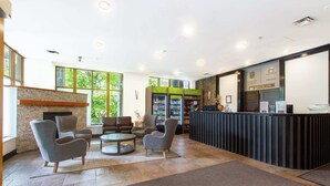 Un hall d’entrée avec un comptoir de réception, un espace salon et une cheminée.