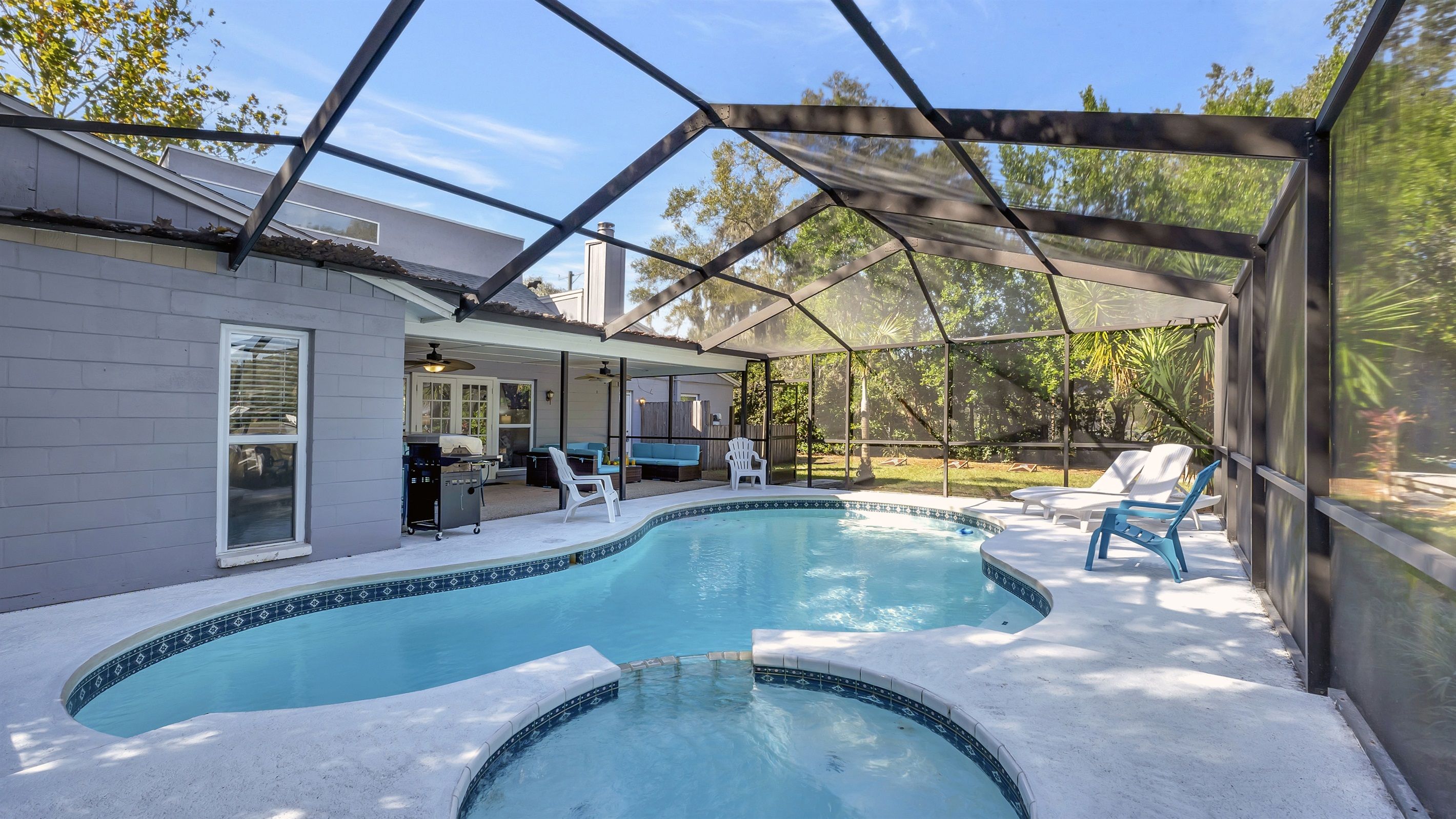 Ein Garten mit Swimmingpool, überdachter Terrasse und umzäunter Grundstück.