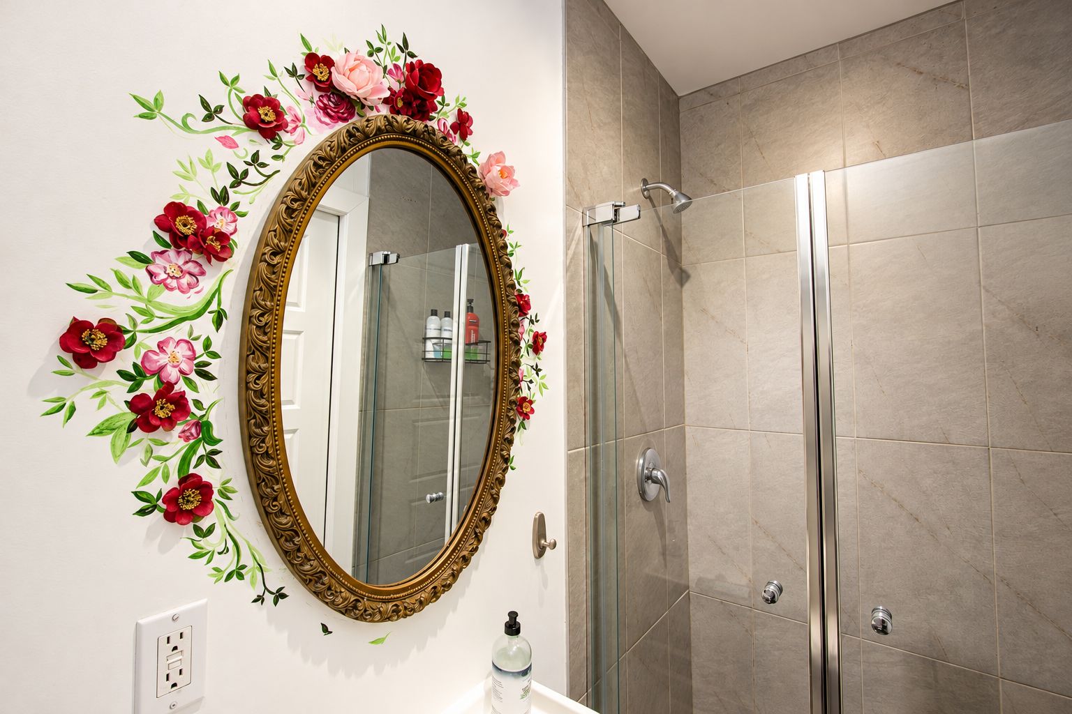 A bathroom with a large ornate mirror, a shower, and a wall-mounted outlet.