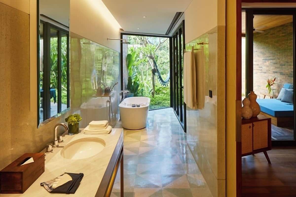 A modern bathroom with a large sink, a bathtub, and a glass shower enclosure.