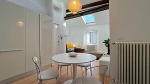 A modern kitchen with a round dining table, two chairs, and a hanging light fixture. - Casa Moira - Affitti Brevi Italia (Lecco)