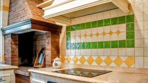 A kitchen with a brick oven, a tiled backsplash, and a countertop.