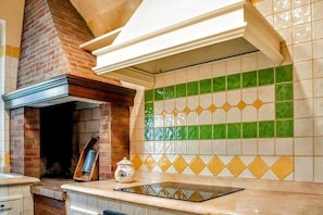 Una cocina con horno de ladrillo, salpicadero de azulejos y encimera.