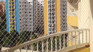 A chain-link fence with a view of multi-story buildings, including a yellow building with balconies. - Temporada Thermas Place Suítes Caldas Novas (Caldas Novas)