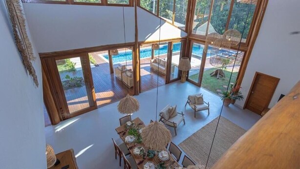 A spacious room with a large window overlooking a pool and outdoor seating area.