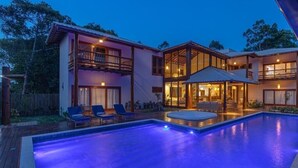 A two-story house with a swimming pool and outdoor seating area.