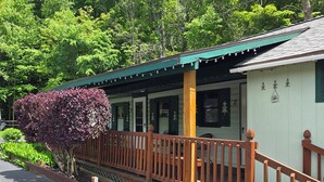 A building with a wooden deck, a covered porch, and a number '2' sign. - Adirondack Sunrise Motel and Cabins (Lake George)