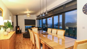 Une cuisine moderne dotée d’une grande table à manger, de meubles en bois et d’une cuisinière intégrée.