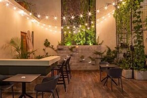 A cozy restaurant with a wooden floor, a counter, and several tables and chairs.