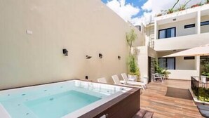 Ein modernes Außenpool-Bereich mit Liegestühlen und einer Holzterrasse.