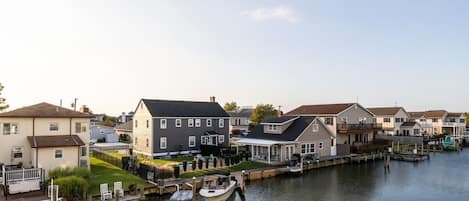 Um bairro residencial com casas ao longo de um canal, cais e um barco.