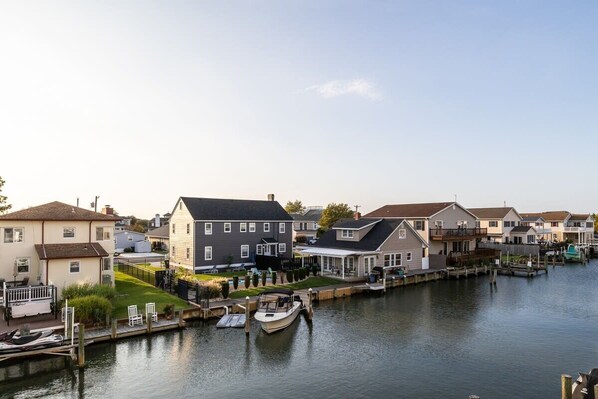 A residential area with houses along a waterway, docks, and a boat.