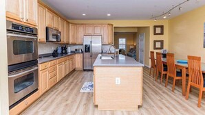 A modern kitchen with wooden cabinets, stainless steel appliances, and a central island.