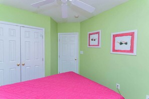 A bedroom with a bed, two doors, a ceiling fan, and two framed pictures on the wall. - Sunset Island Townhouse - 5 Bdr/ Sleeps 12/ pool (Ocean City)