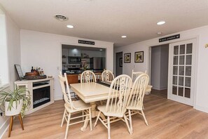 A dining area with a wooden table and chairs, a small cabinet with decorative items, and a potted plant. - "The Hive"-Downtown Berlin, 4 BR, Sleeps 8, 2 Bath (Berlin)