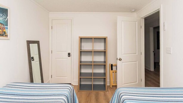 Une chambre avec deux lits, une armoire et un miroir.