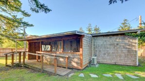 Eine kleine Holzhütte mit überdachter Veranda und einer Ziegelwand.