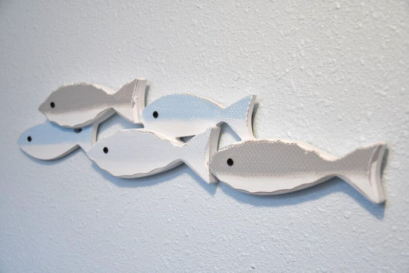 A wall with four white fish-shaped decorations.