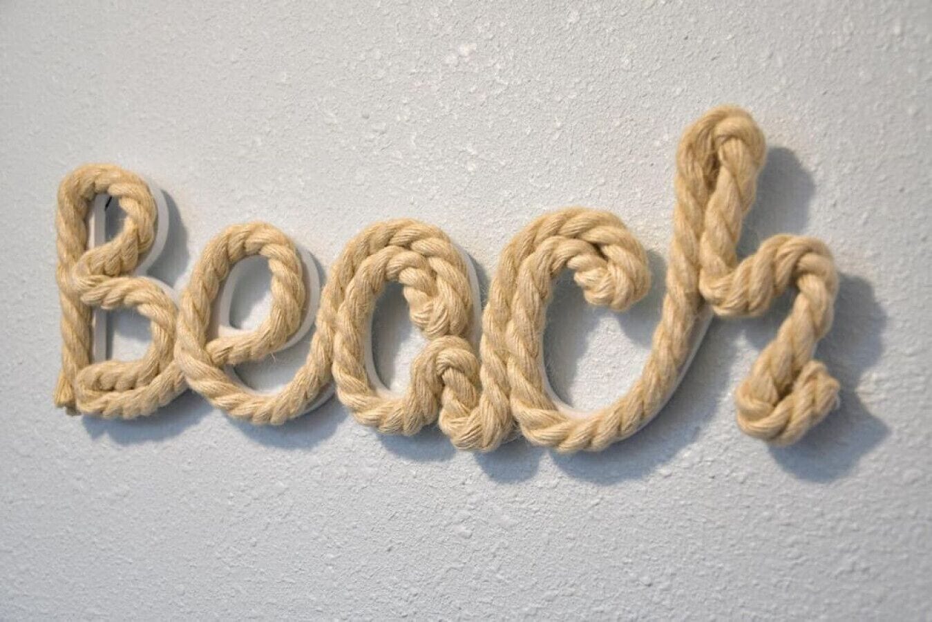 Una pared con la palabra 'Beach' escrita con letras de cuerda.