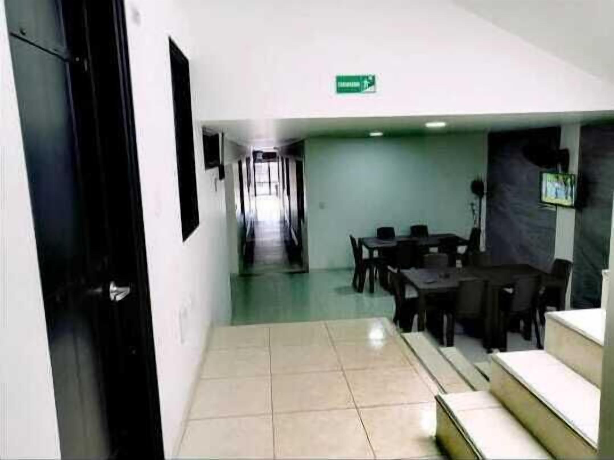 Ein Hotelkorridor mit einer Rezeption, einem Essbereich und einer Treppe.