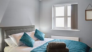 A bedroom with a bed, a window, and a radiator. - The Gainsborough Mews (Gainsborough)