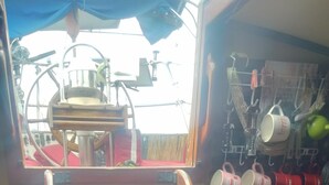 A kitchen area with wooden steps leading to a window, a coffee machine, and a rack with mugs. - sailboat on the bay ,close to South Beach and Winwood. (Miami)
